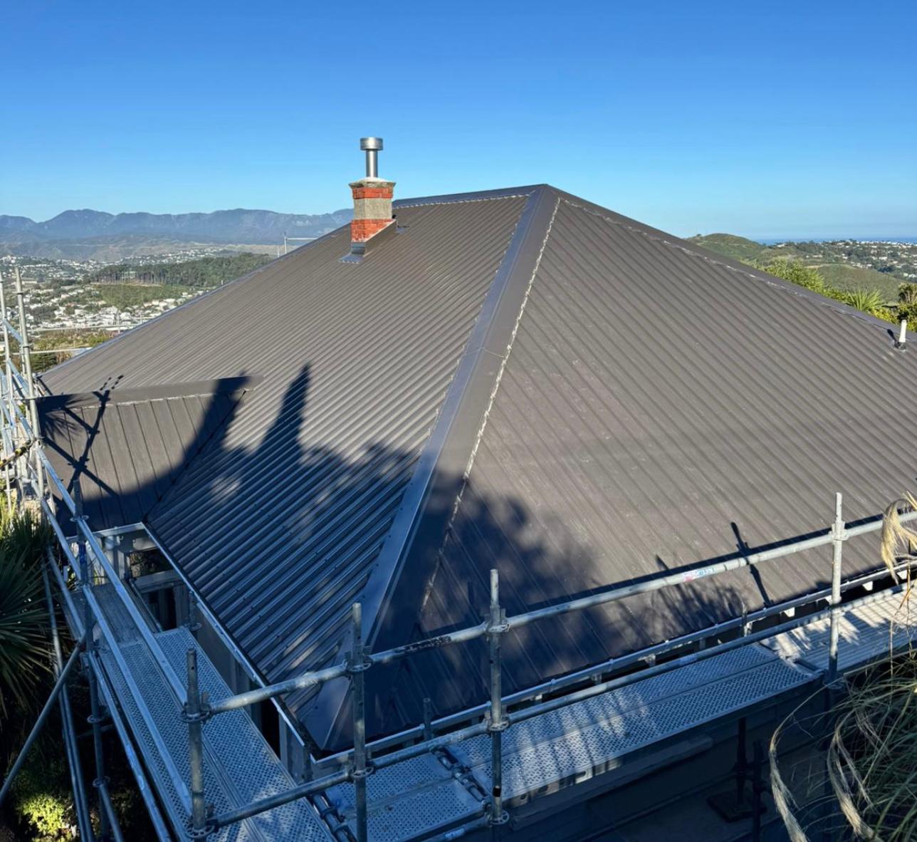 Completed dark long-run metal roof on a Wellington hillside home